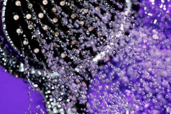 El banyosu başlığı, deliklerden akan su püskürtüleriyle yakın çekim makro fotoğrafçılık, kısa pozlama.