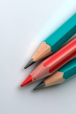 Beyaz arka planda iki basit ve bir kırmızı kalem, yakın plan makro fotoğraf.