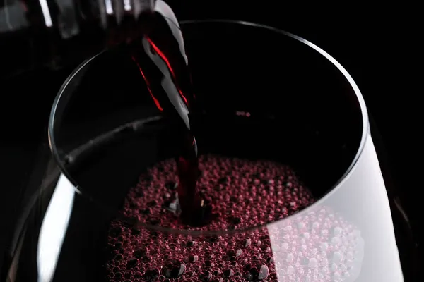 Trockener Rotwein Wird Ein Glas Auf Schwarzem Hintergrund Gegossen Nahaufnahme — Stockfoto