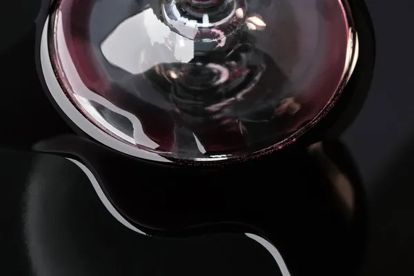 在一个黑色背景的特写宏观摄影中 红酒洒在杯子旁边 — 图库照片