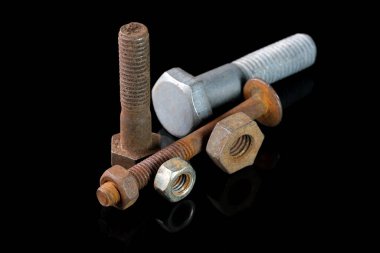 Siyah aynalı arka planda kullanılmış cıvatalar ve fındıklar yakın plan makro fotoğrafçılık