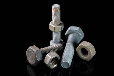 Siyah aynalı arka planda kullanılmış cıvatalar ve fındıklar yakın plan makro fotoğrafçılık