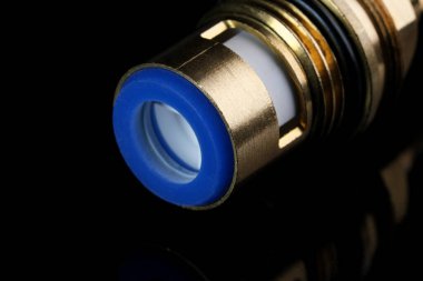 Siyah ayna arka planında seramik plakalı musluk aksı kutusu yakın plan makro fotoğraf.