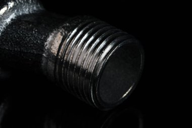 Mikserle banyodaki su borusunu birbirine bağlamak için eksantrik bir adaptör. Arka planda siyah aynalı makro fotoğraf makinesi.