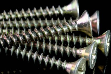 Siyah arka plan yakın çekim makro fotoğrafçılık üzerinde bir tornavida için uzun vidalar