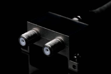 Eş eksenli televizyon kablosunun siyah ayna arkaplanındaki iki çıktıya, yakın plan makro fotoğrafçılığa bölünmesi