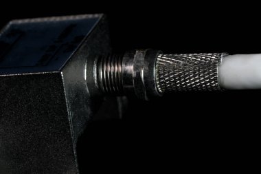 Eş eksenli televizyon kablosunun siyah ayna arkaplanındaki iki çıktıya, yakın plan makro fotoğrafçılığa bölünmesi