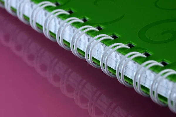 Сорванный Спиральный Блокнот Розовом Зеркальном Фоне Зеленой Обложке Крупным Планом — стоковое фото