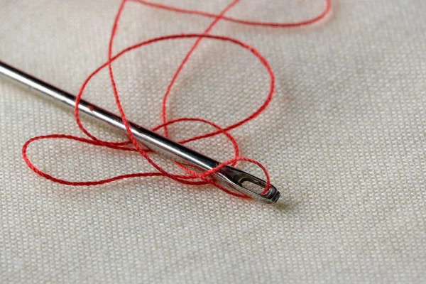 白いリネンの布の上に糸を挿入した針を閉じるマクロ写真 — ストック写真