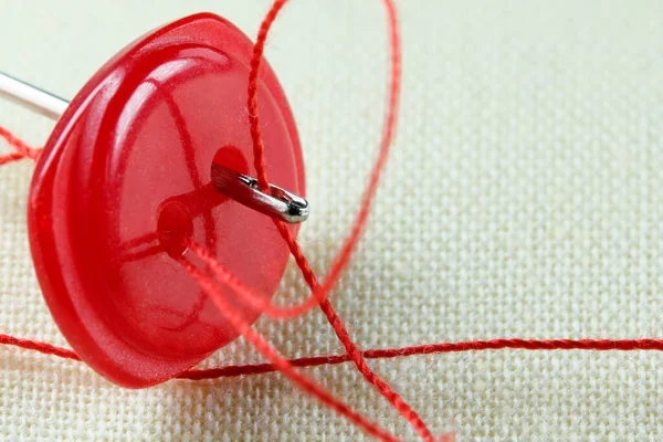 Botão Vermelho Com Uma Agulha Com Fio Inserido Pano Linho — Fotografia de Stock