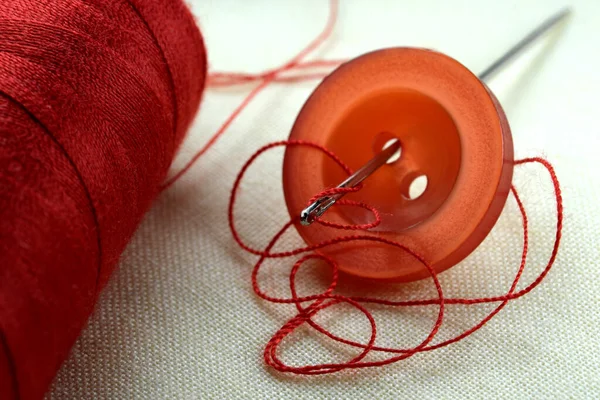 Botão Vermelho Com Uma Agulha Com Fio Inserido Pano Linho — Fotografia de Stock