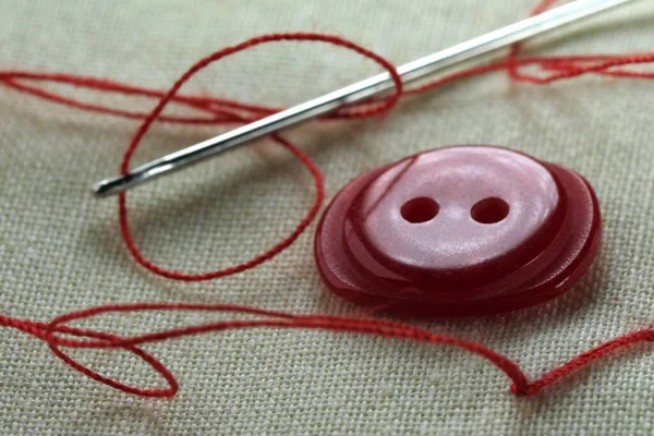 Roter Knopf Mit Einer Nadel Mit Eingesetztem Faden Auf Einem — Stockfoto