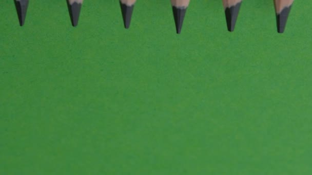 緑色の背景ビデオクリップの上から6本のシンプルな鉛筆が動いています — ストック動画