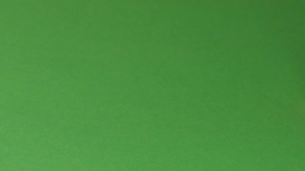Невеликий Загострений Червоний Олівець Стоїть Зеленому Папері Рухається Відношенню Відеокамери — стокове відео