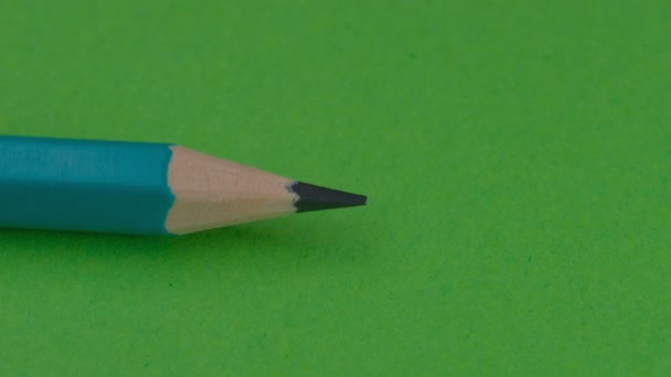 左側にシンプルな木製の鉛筆が表示され 緑色の背景に消しゴム ビデオクリップ クローズアップで右側の鉛筆でブロックされます — ストック動画