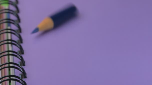 Появляется Маленький Заостренный Синий Деревянный Карандаш Стоит Фиолетовой Тетради Видеоклипе — стоковое видео