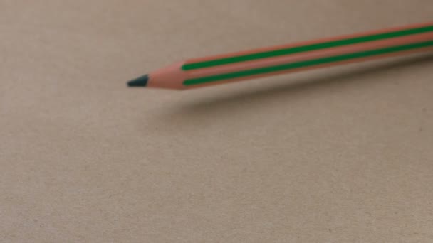 两支绿色铅笔的战斗以小铅笔在棕色纸板表面 视频剪辑 特写上的胜利而告终 — 图库视频影像