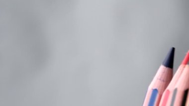 Renkli kalemler yavaş hareket eder. Karmaşık, sivri uçlu arka plan, yakın çekim, yavaş çekim, video klipte biter.