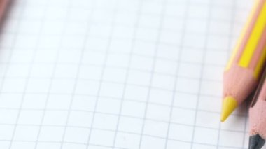 Renkli kalemler yavaş hareket eder, ucu sivri uçlar açık bir defter, yakın çekim, yavaş çekim, video klip