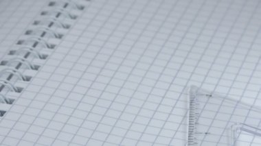 Cetvel, ataç ve üç küçük kalem işaretli bir defter üzerinde hareket eder, yakın çekim, yavaş çekim, video klip