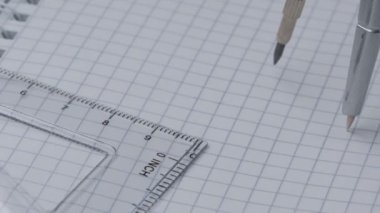Pusula açık kareli bir defter, yakın çekim, yavaş çekim, video klip üzerinde yavaşça bir çember çizer
