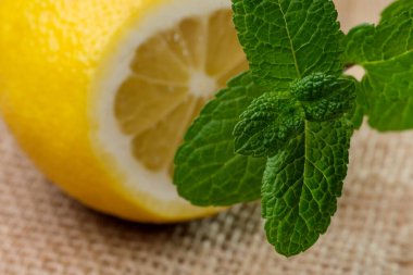 Kokulu nane yapraklarının yanında peçete olan bir masaya limon yakın plan kes.