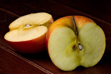 Ahşap bir arka planda çürümüş çürümüş elmaların yarısı.