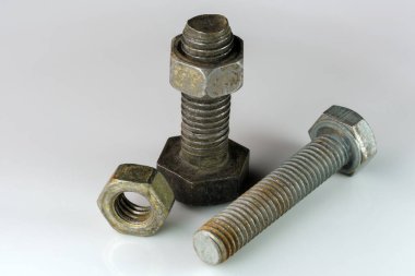 Old rusty bolts and nuts on a white mirror background close-up macro photography