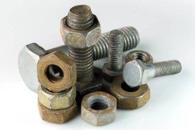 Old rusty bolts and nuts on a white mirror background close-up macro photography