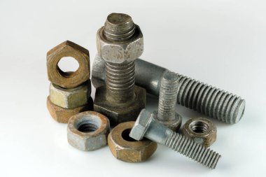 Old rusty bolts and nuts on a white mirror background close-up macro photography