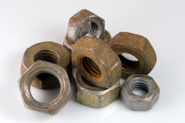 Old rusty nuts on a white mirror background close-up macro photography