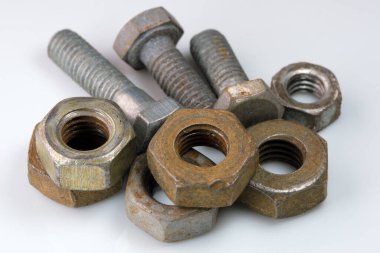 Old rusty bolts and nuts on a white mirror background close-up macro photography