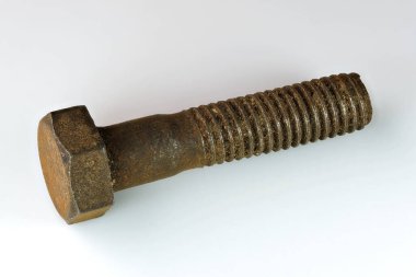 Old rusty bolt on a white mirror background close-up macro photography