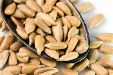 Kavrulmuş ayçiçeği tohumları çay kaşığında yakın plan beyaz bir aynada.