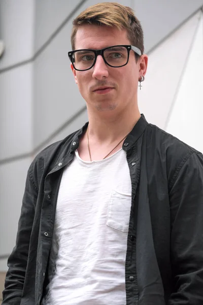 Portrait of a young handsome guy in a black shirt close-up autumn street photography