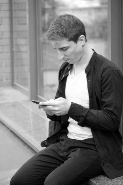 Siyah tişörtlü yakışıklı bir adamın siyah beyaz portresi sonbahar sokak fotoğrafçılığı.