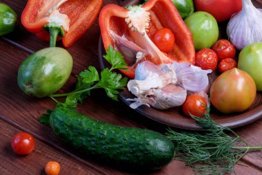 Sebzeli ve sarımsaklı bir hayat kahverengi bir masanın üzerinde duruyor.