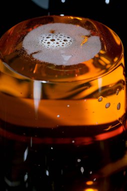 Siyah arka plan makro fotoğrafında taze hafif bira şişesi.
