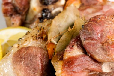 Evde fırında pişirilmiş nefis kokulu domuz budu ve yakın plan beyaz bir tabakta baharatlar.