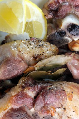 Evde fırında pişirilmiş nefis kokulu domuz budu ve yakın plan beyaz bir tabakta baharatlar.