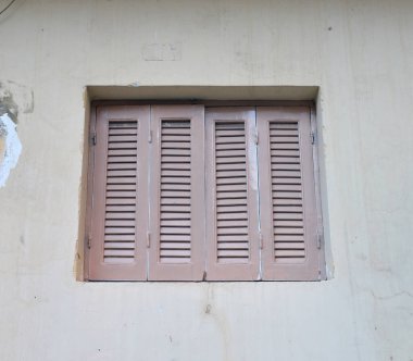 Evin duvarındaki pencere kapalı panjurlar..