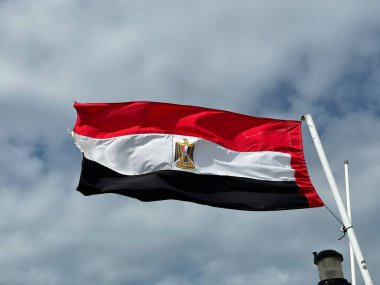 Flag of Arab Republic of Egypt on a blue sky background.