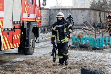 ZHYTOMYR, UKRAINE - 8 Mart 2022: Rusya 'nın Ukrayna' ya karşı savaşı. Kiev yakınlarındaki büyük bir şehirde, düşman uçakları ve füzeleri bir eve zarar veriyor. İtfaiyeciler yangını söndürdü. Kurtarma ekipleri evin enkazını sökün..