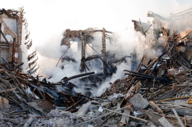 ZHYTOMYR, UKRAINE - 8 Mart 2022: Rusya 'nın Ukrayna' ya karşı savaşı. Kiev yakınlarındaki büyük bir şehirde, düşman uçakları ve füzeleri bir eve zarar veriyor. İtfaiyeciler yangını söndürdü. Kurtarma ekipleri evin enkazını sökün..