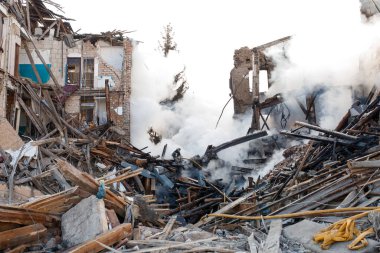 ZHYTOMYR, UKRAINE - 8 Mart 2022: Rusya 'nın Ukrayna' ya karşı savaşı. Kiev yakınlarındaki büyük bir şehirde, düşman uçakları ve füzeleri bir eve zarar veriyor. İtfaiyeciler yangını söndürdü. Kurtarma ekipleri evin enkazını sökün..