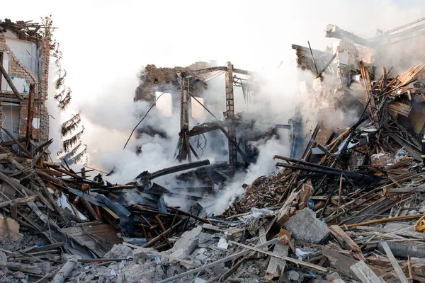 ZHYTOMYR, UKRAINE - 8 Mart 2022: Rusya 'nın Ukrayna' ya karşı savaşı. Kiev yakınlarındaki büyük bir şehirde, düşman uçakları ve füzeleri bir eve zarar veriyor. İtfaiyeciler yangını söndürdü. Kurtarma ekipleri evin enkazını sökün..