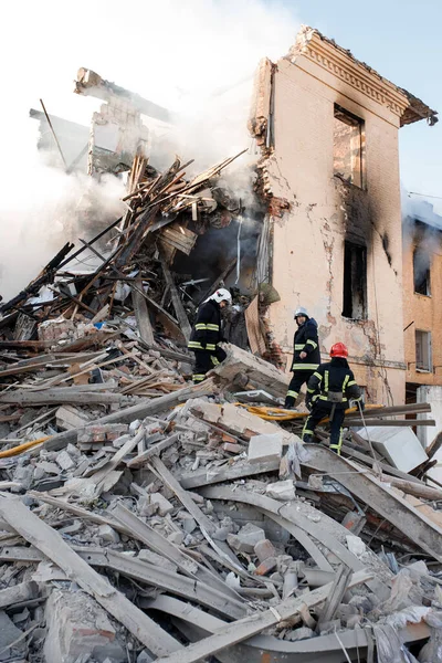 ZHYTOMYR, UKRAINE - 8 Mart 2022: Rusya 'nın Ukrayna' ya karşı savaşı. Kiev yakınlarındaki büyük bir şehirde, düşman uçakları ve füzeleri bir eve zarar veriyor. İtfaiyeciler yangını söndürdü. Kurtarma ekipleri evin enkazını sökün..