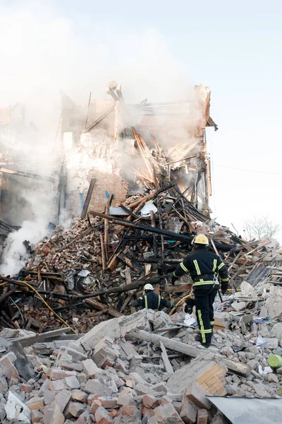 ZHYTOMYR, UKRAINE - 8 Mart 2022: Rusya 'nın Ukrayna' ya karşı savaşı. Kiev yakınlarındaki büyük bir şehirde, düşman uçakları ve füzeleri bir eve zarar veriyor. İtfaiyeciler yangını söndürdü. Kurtarma ekipleri evin enkazını sökün..