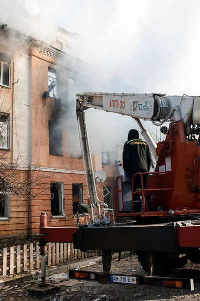 ZHYTOMYR, UKRAINE - 8 Mart 2022: Rusya 'nın Ukrayna' ya karşı savaşı. Kiev yakınlarındaki büyük bir şehirde, düşman uçakları ve füzeleri bir eve zarar veriyor. İtfaiyeciler yangını söndürdü. Kurtarma ekipleri evin enkazını sökün..
