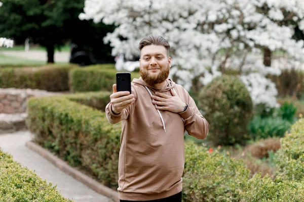 Adam manolyanın arka planında neşeyle selfie çekiyor. Video aracılığıyla iletişim kuruyor. Çevresini gösteriyor..